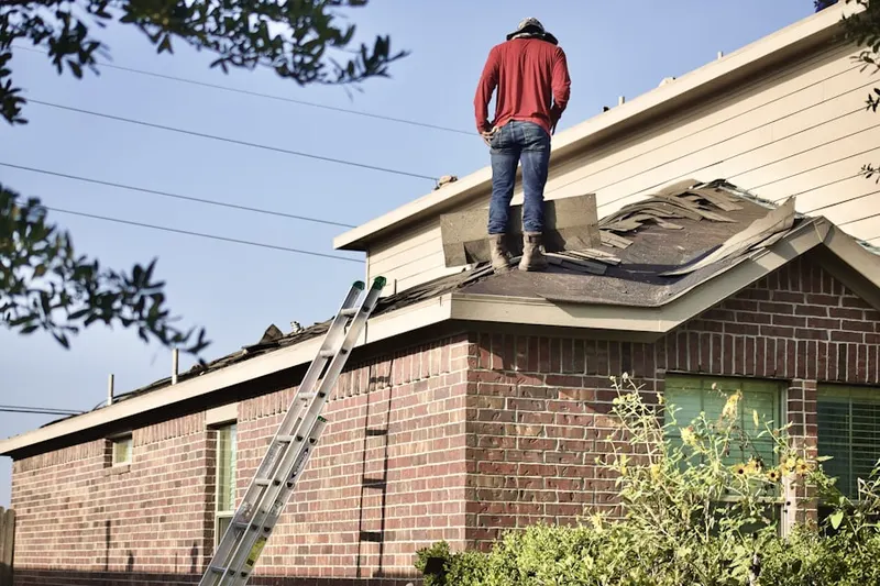 Professional roofer working on a residential roof in Wellesley Fells